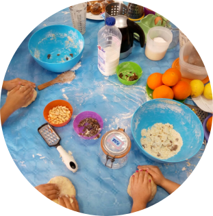 Taller de cocina en inglés Niños amasando e ingredientes de cocina sobre una mesa